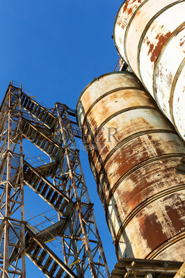 旧的,废弃的混凝土工厂有生锈的铁罐和金属结构。危机爆发,经济下滑,生产能力停止导致崩溃。全球灾难。照片摄影